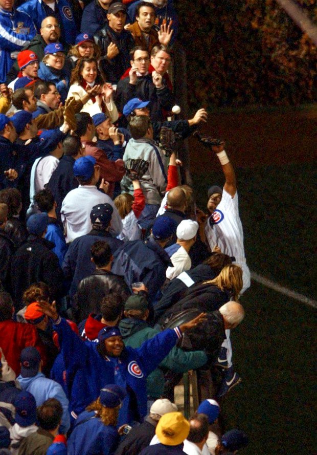 Fan Steve Bartman deflects a foul ball that Chicago Cubs outfielder Moises Alou might or might not have caught in the infamous 2003 NLCS at Wrigley Field on Oct. 14, 2003. Bartman has remained in virtual hiding since the incident. (Charles Cherney/Chicago Tribune)