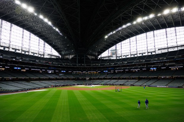 Cubs players warm up before playing the Brewers in Game...