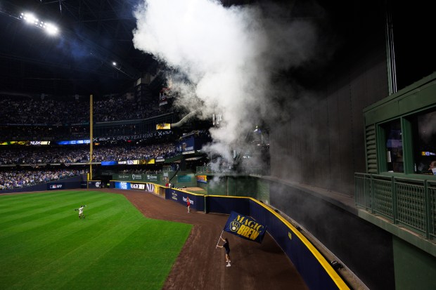 A person carries a Milwaukee Brewers flag during player introductions...