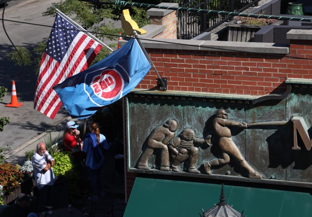 Fans relax outside of Murphy’s Bleachers beside Wrigley Field in...