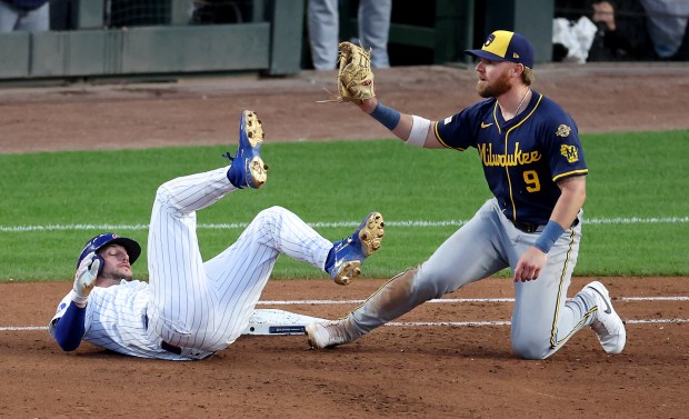 Chicago Cubs designated hitter Kyle Tucker lies on the ground...