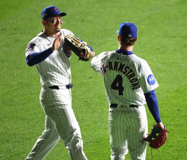 Chicago Cubs right fielder Seiya Suzuki, left, and center fielder...