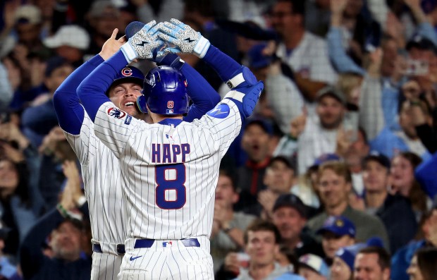 Cubs left fielder Ian Happ is congratulated by teammate Nico...