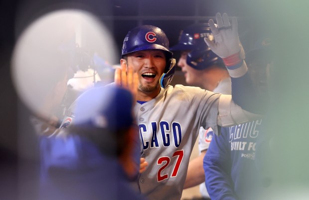 Cubs right fielder Seiya Suzuki is congratulated in the dugout...