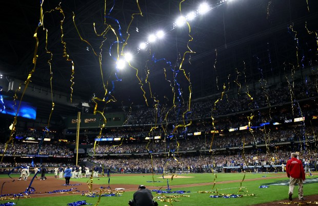 Confetti falls as the Brewers celebrate after defeating the Cubs...