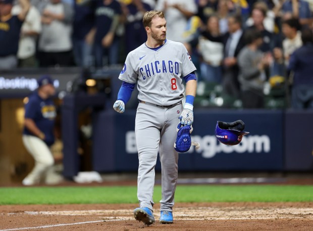 Chicago Cubs left fielder Ian Happ tosses his helmet aside...