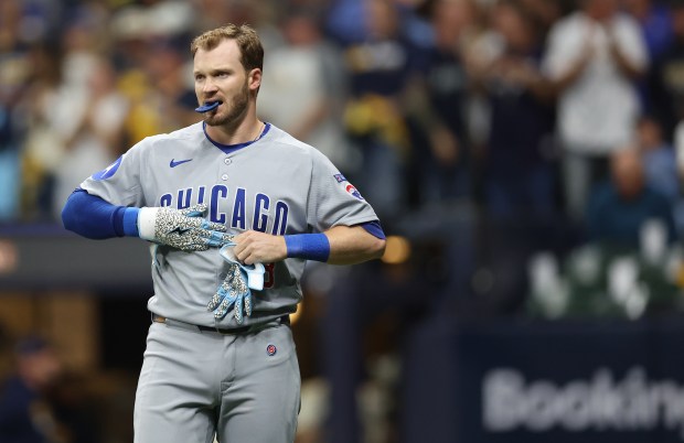 Chicago Cubs left fielder Ian Happ takes off his batting...