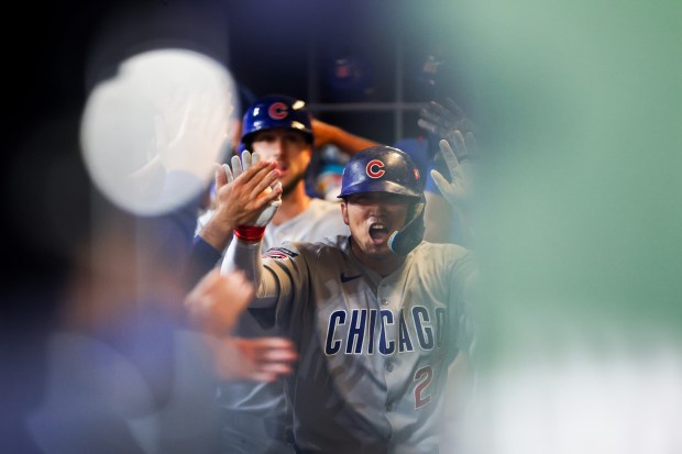 Chicago Cubs outfielder Seiya Suzuki (27) celebrates in the dugout...