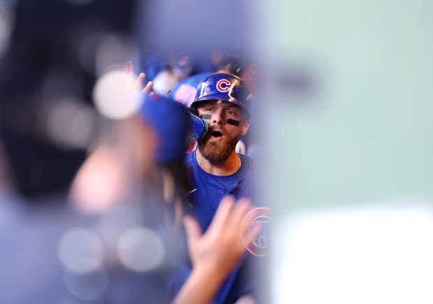 Chicago Cubs first baseman Michael Busch is congratulated by his...