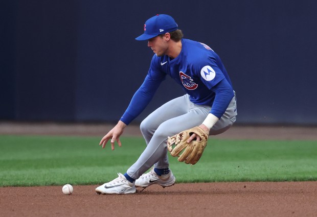 Cubs second baseman Nico Hoerner picks up the ball after...