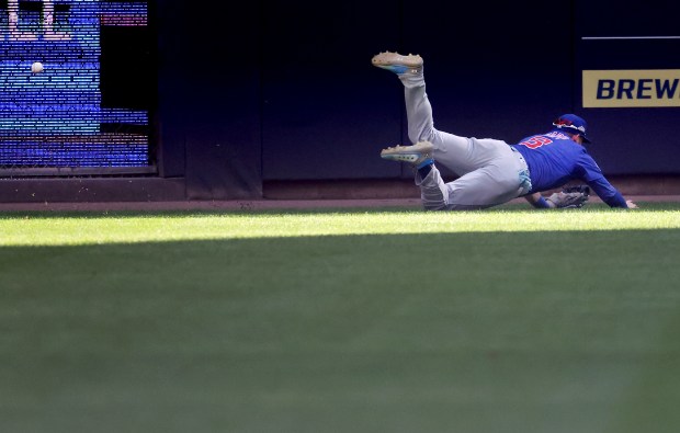 Chicago Cubs left fielder Ian Happ is unable to catch...