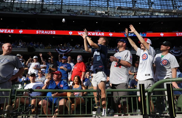 A Chicago Cubs fan catches a free shirt in the...
