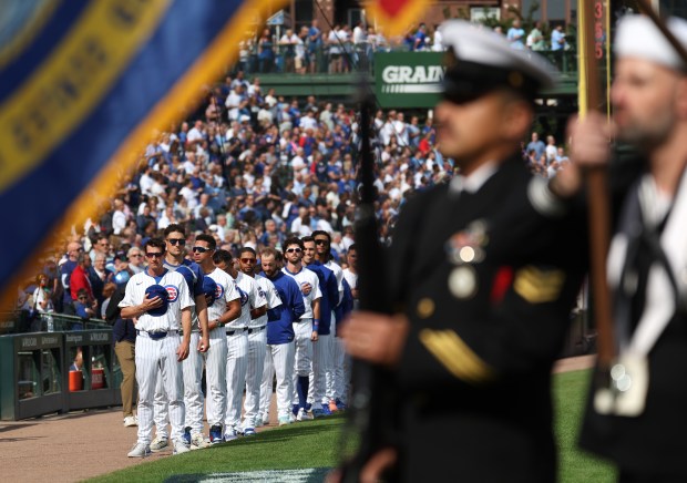 Chicago Cubs manager Craig Counsell and his team stand for...