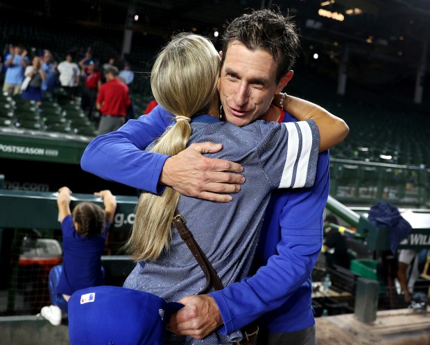 Chicago Cubs manager Craig Counsell receives a hug on the...