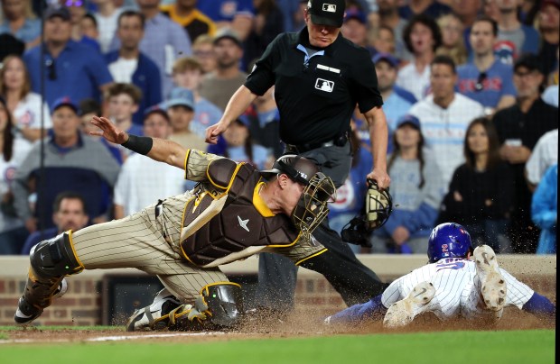 Padres catcher Freddy Fermin tags out Cubs second baseman Nico...