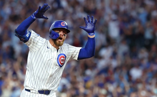 Cubs first baseman Michael Busch celebrates as he rounds the...