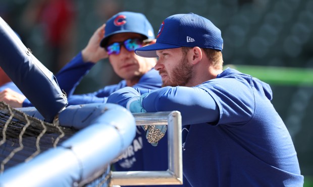 Chicago Cubs left fielder Ian Happ, right, and manager Craig Counsell hang out behind the cage during batting practice for Game 3 of the wild-card series against the Padres at Wrigley Field on Oct. 2, 2025. (Chris Sweda/Chicago Tribune)