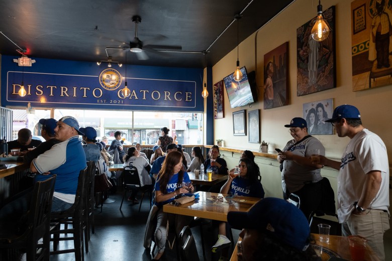 Customers watch a dodger game at Distrito Catorce 