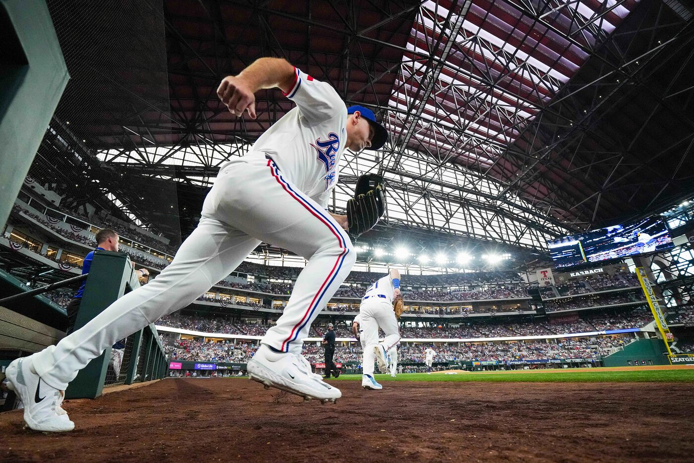 Texas Rangers outfielder Wyatt Langford and first baseman Jake Burger (21) take the field...
