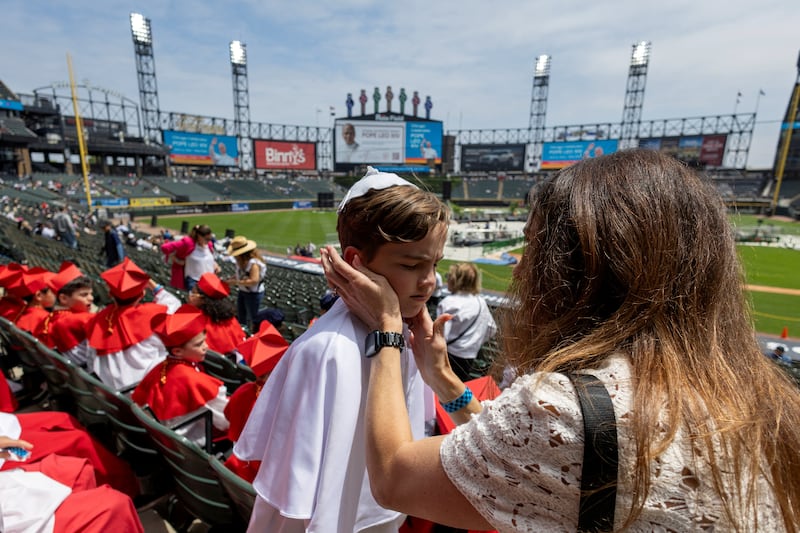 Auggie Wilk, elected pope in a mock Conclave at his school Our Lady of Mount Carmel, has sunscreen applied by his mom ahead of a public celebration hosted by the Chicago White Sox and the Archdiocese of Chicago for the election of Pope Leo XIV, featuring a mass at Rate Field  in Chicago, Illinois, U.S., June 14, 2025.