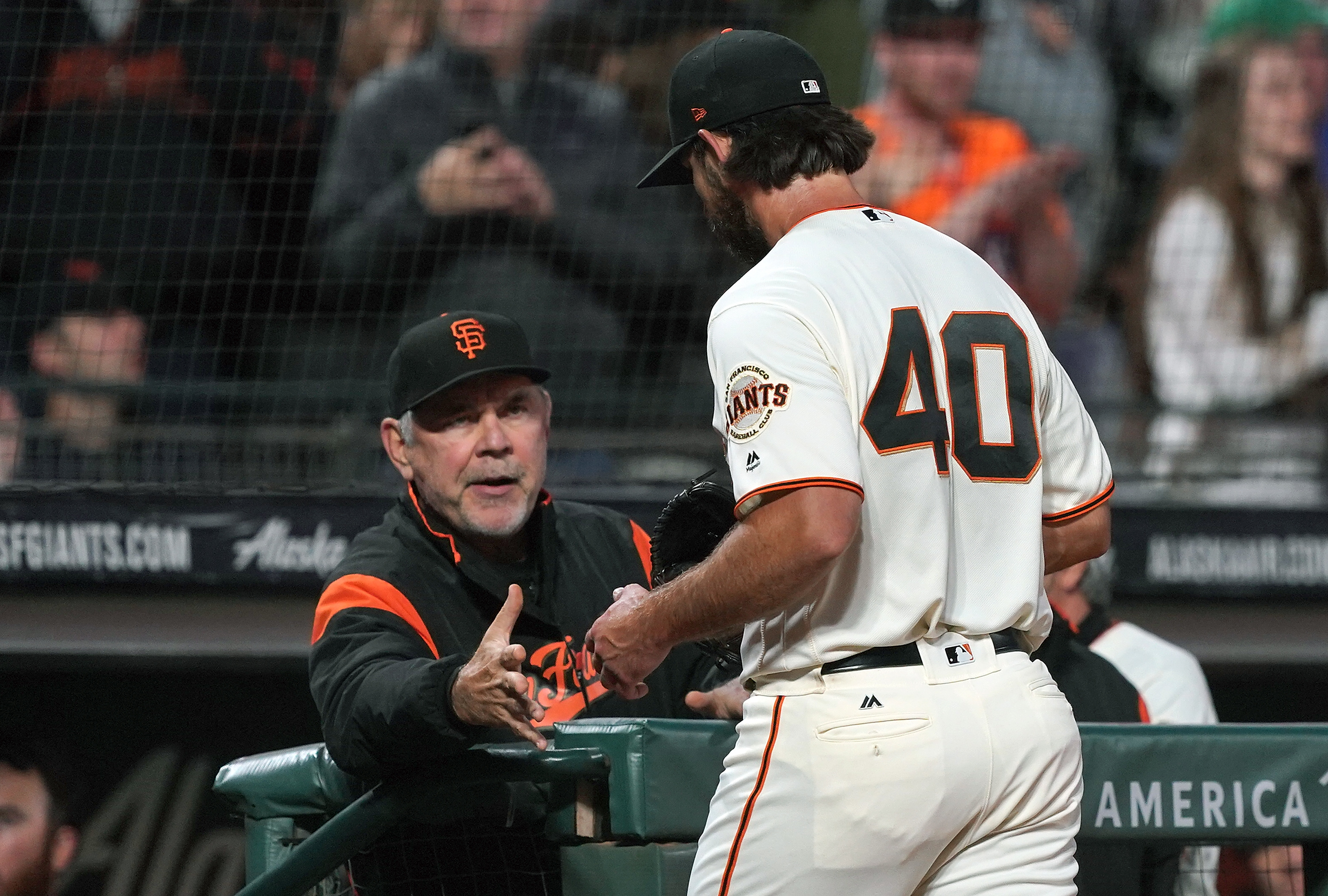 SAN FRANCISCO, CA - JULY 23: Manager Bruce Bochy #15 of the San Francisco Giants reaches out to shake the hand of pitcher Madison Bumgarner #40 as Bumgarner returns to the dugout after the top of the seventh inning against the Chicago Cubs at Oracle Park on July 23, 2019 in San Francisco, California. 