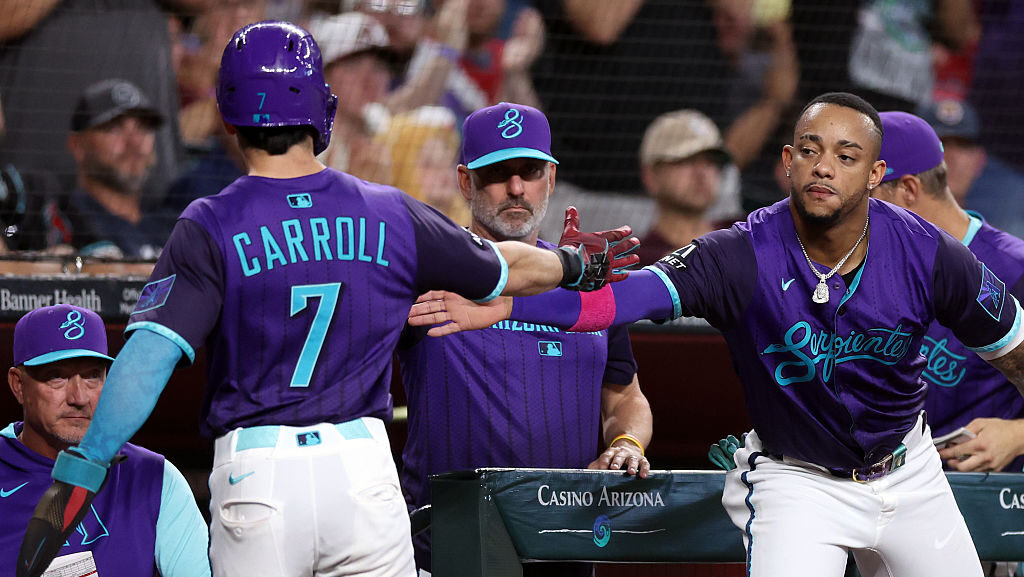 Ketel Marte #4 high fives Corbin Carroll #7 of the Arizona Diamondbacks...