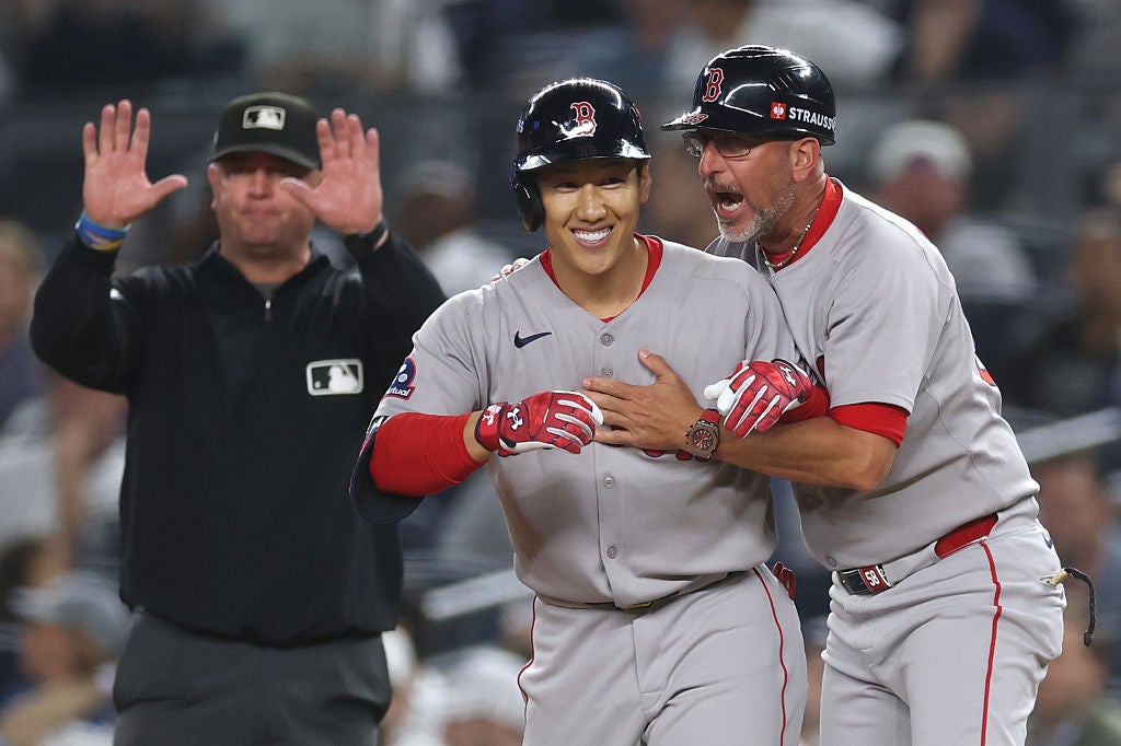 NEW YORK, NEW YORK - SEPTEMBER 30: Masataka Yoshida #7 of the Boston Red Sox celebrates with first base coach José David Flores #58 after hitting a two-run single against the New York Yankees during the seventh inning of game one of the American League Wild Card Series at Yankee Stadium on September 30, 2025 in the Bronx borough of New York City.  (Photo by Ishika Samant/Getty Images)