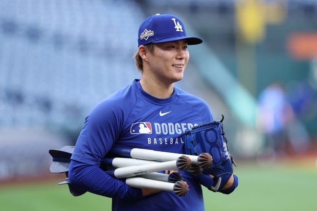 Dodgers pitcher Yoshinobu Yamamoto smiles during warmups before playing the...