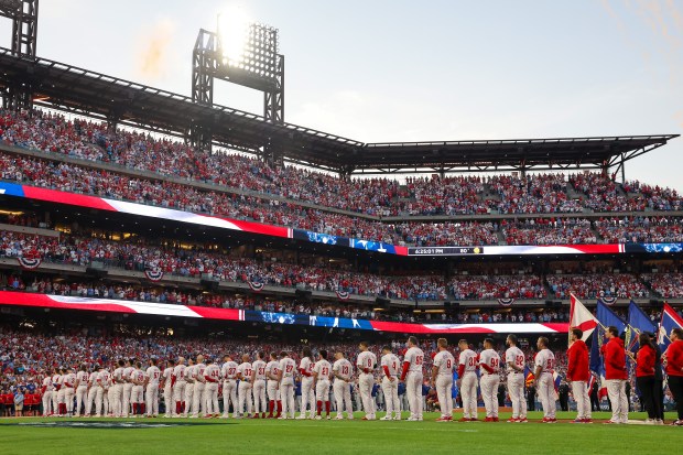 The Philadelphia Phillies stand in line during the national anthem...