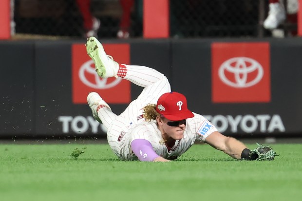 Philadelphia Phillies center fielder Harrison Bader dives to make a...