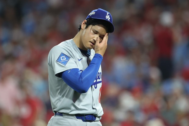 Dodgers starting pitcher Shohei Ohtani reacts after the fourth inning...