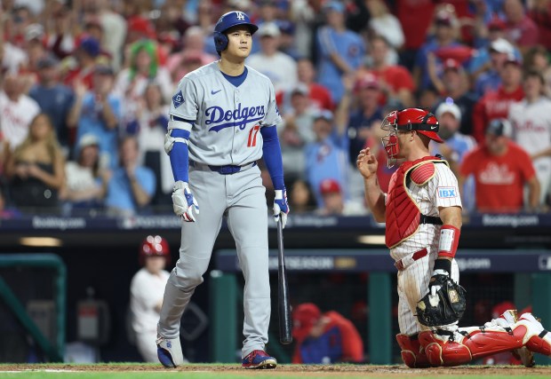 Dodgers star Shohei Ohtani reacts after striking out in the...