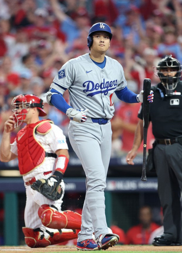 Dodgers star Shohei Ohtani reacts after striking out in the...