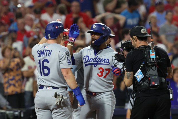 The Dodgers’ Teoscar Hernandez, right, celebrates his go-ahead three-run home...