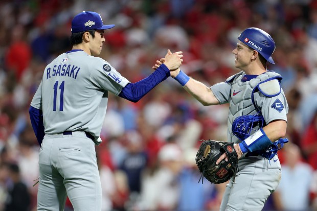 Dodgers relief pitcher Roki Sasaki, left, and catcher Will Smith...