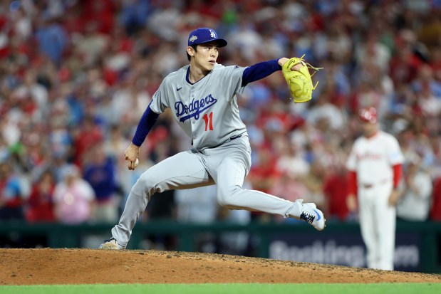 Dodgers relief pitcher Roki Sasaki throws to the plate in...