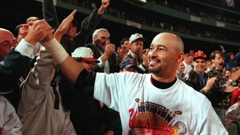 Red Sox leftfielder Mike Greenwell ventures into unfamiliar territory, the right field stands to high five fans along the railing follwoing the victory.