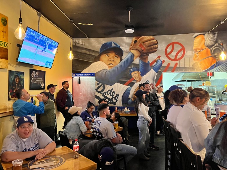 Customers watch a Dodgers game at a bar