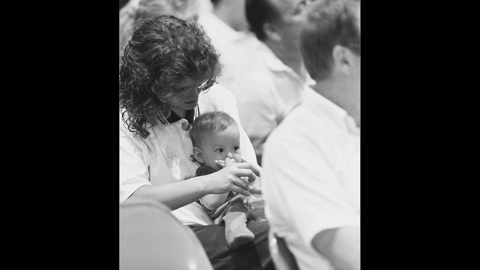 Diane Schemmel holds daughter Sabrina on July 19, 1990, during a memorial service on the one-year anniversary of the crash of United Flight 232.