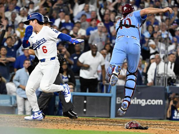 The Dodgers’ Hyeseong Kim, left, scores the winning run as...
