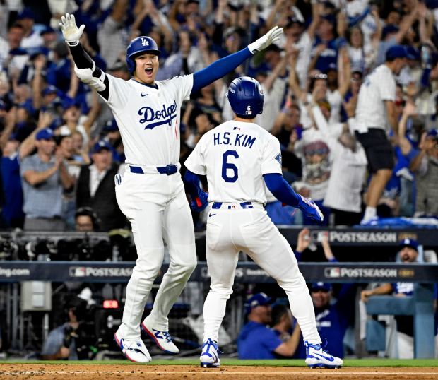 Dodgers star Shohei Ohtani, left, celebrates with teammate Hyeseong Kim...