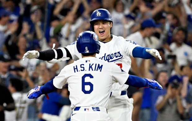 Dodgers star Shohei Ohtani, top, celebrates with teammate Hyeseong Kim...