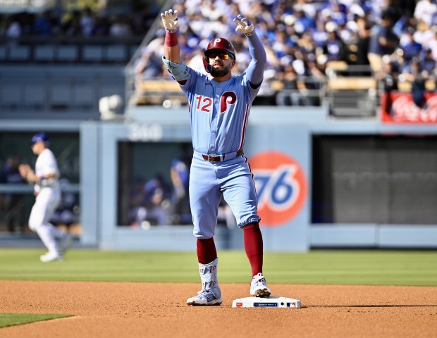Philadelphia Phillies slugger Kyle Schwarber gestures to his dugout after...