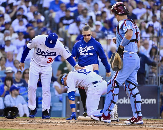 Dodgers manager Dave Roberts checks on Alex Call (12) after...