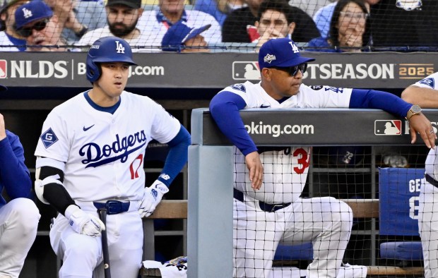 Dodgers star Shohei Ohtani, left, and Manager Dave Roberts look...