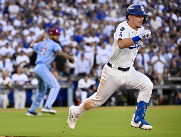 The Dodgers’ Tommy Edman, right, grounds out to Philadelphia Phillies...