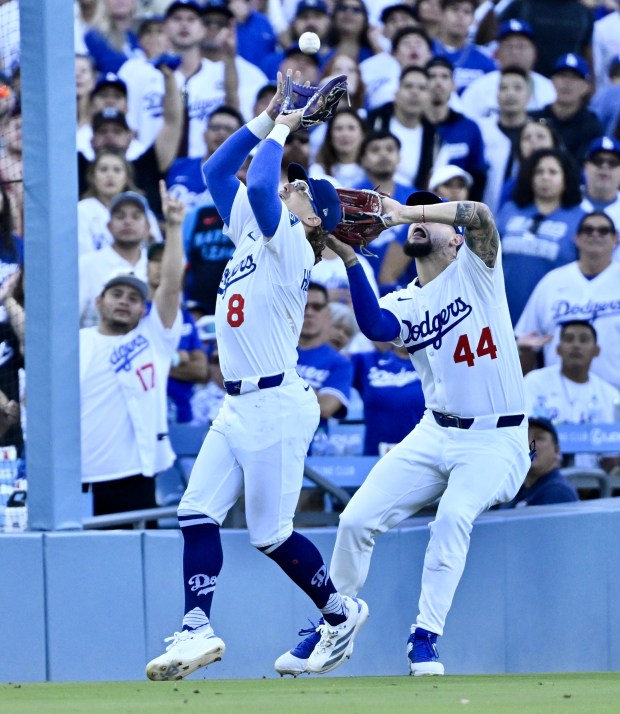 Dodgers third baseman Kike Hernandez, left, catches a pop-up in...