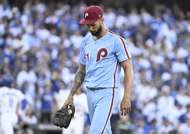 Philadelphia Phillies starting pitcher Cristopher Sanchez walks off the field...