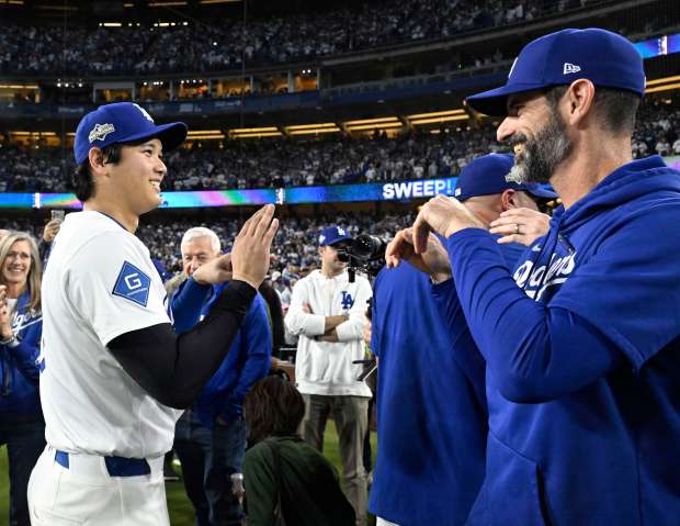 Shohei Ohtani, left, celebrates with pitching coach Mark Prior after...