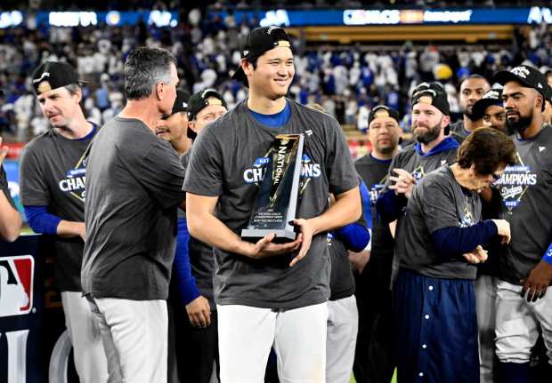Dodgers star Shohei Ohtani poses with the NLCS MVP trophy after his epic performance in Game 4 of the National League Championship Series against the Milwaukee Brewers on Friday night at Dodger Stadium. Ohtani hit three home runs and pitched six scoreless innings in the series-clinching 5-1 win. (Photo by Keith Birmingham, Pasadena Star-News/SCNG)